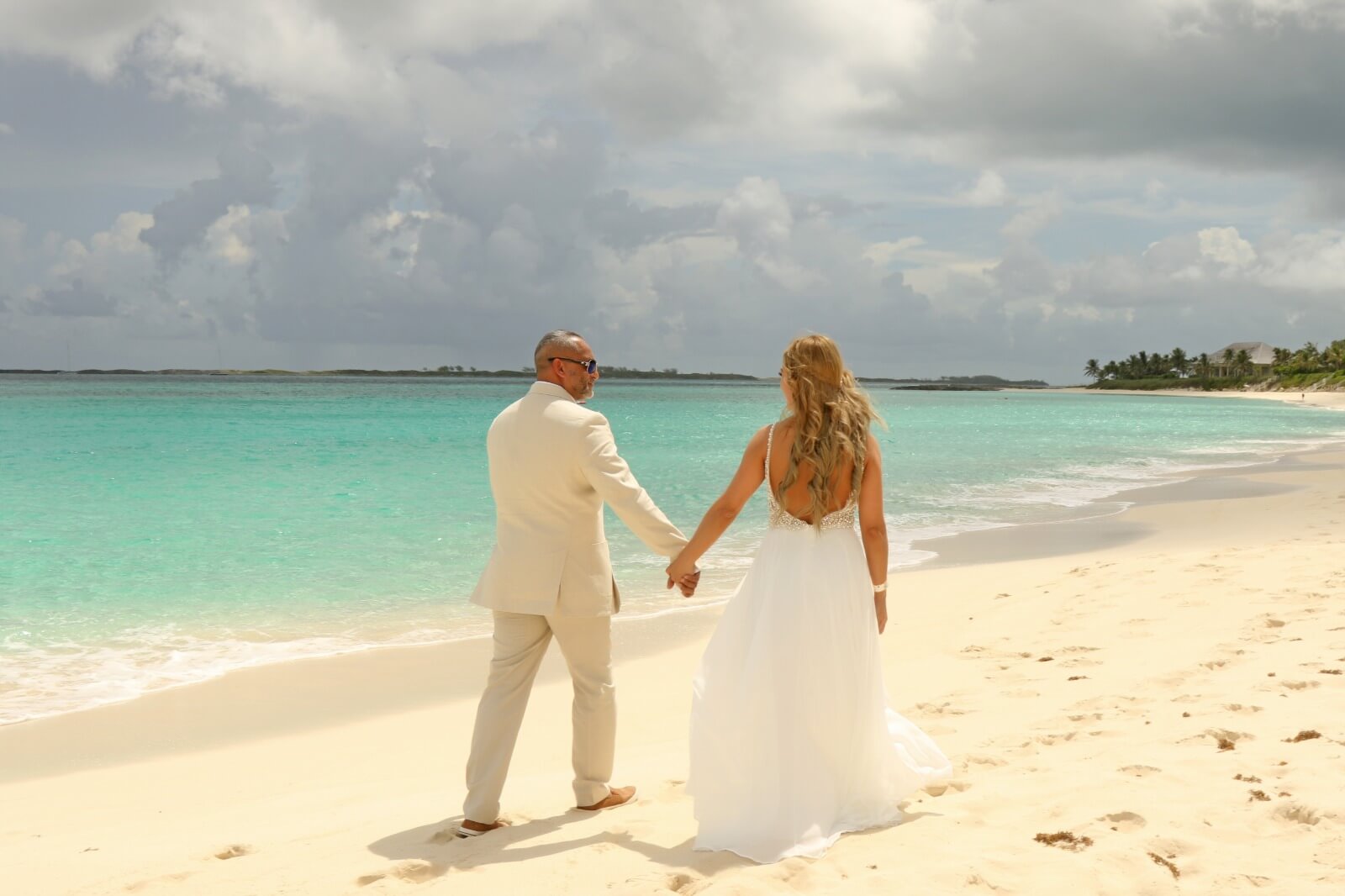 A couple walking along the beach during their Bahamas wedding on Paradise Island.