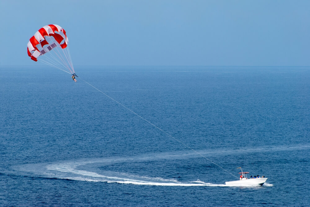 A person parasailing in Nassau when visiting the Bahamas in the winter.